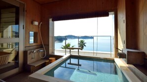 Una cabaña de madera con piscina cubierta, ducha y vista al mar.
