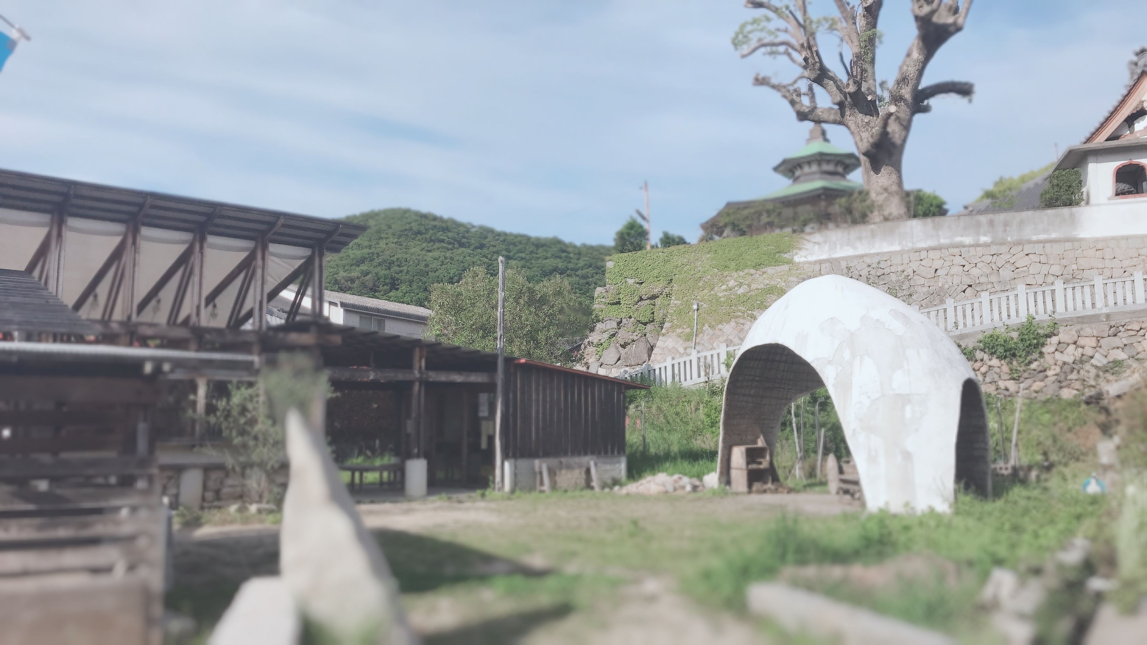 A traditional Japanese building with a large stone bridge and a pagoda in the background.