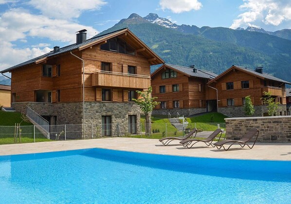 Una piscina al aire libre, tumbonas