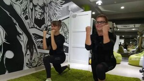 Una habitación con alfombra verde, una puerta blanca y un mural blanco y negro en la pared.