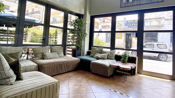 A spacious room with large windows, a ceiling fan, and a seating area with couches and a coffee table.