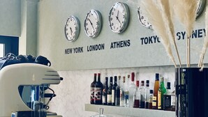 A bar area with clocks indicating New York, London, Athens, and Tokyo times.