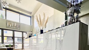 A spacious kitchen with a large island, modern lighting fixtures, and large windows allowing natural light.