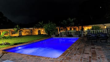 Alberca al aire libre y camastros