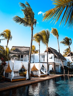 Un resort con piscina, edificios blancos y palmeras.