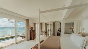 Un dormitorio amplio con una cama grande, vistas al mar y un balcón.