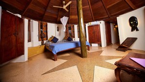 Une pièce avec un lit, un plafond en bois et un sol orné de motifs en forme d’étoiles.