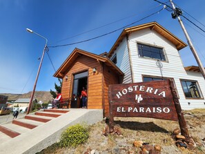A wooden building with a sign reading "Hosteria El Paraiso". - Hosteria El Paraiso (El Chalten)