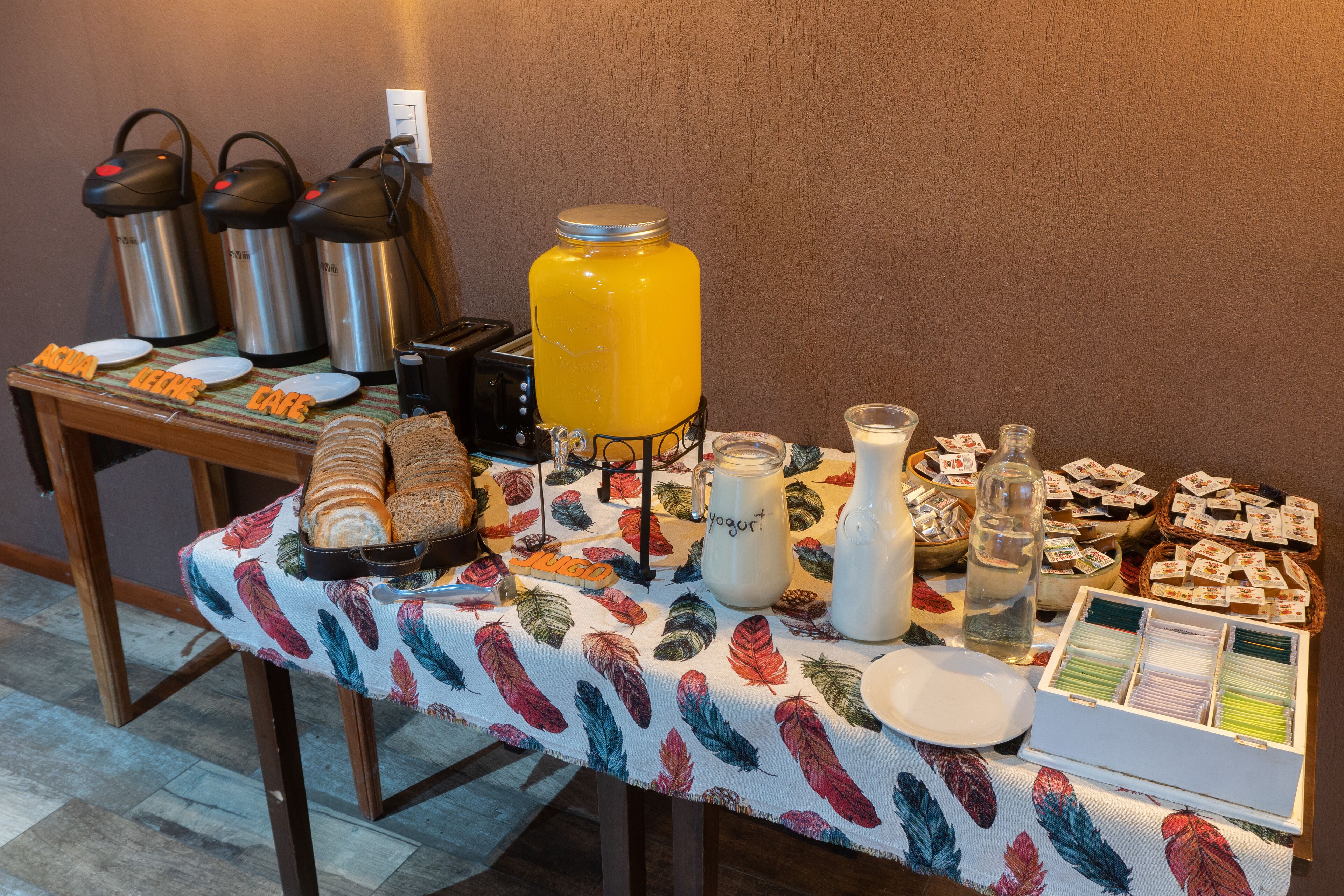 A breakfast buffet with various food items, a coffee station, and a juice dispenser.