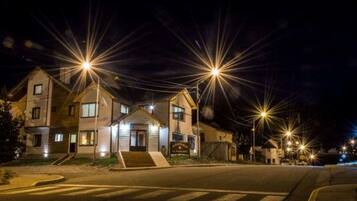 Una calle residencial iluminada por farolas durante la noche.