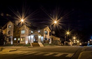 Una calle residencial iluminada por farolas durante la noche.
