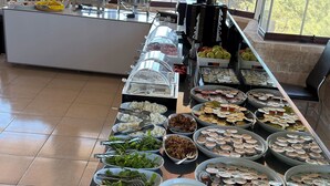Ein reichhaltiges Buffet mit verschiedenen Speisen und einer Kaffeestation.