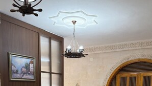 Ein Hotelzimmer mit zwei Betten, einem Schreibtisch, einem Stuhl, einem Gemälde und einer Chandelier.