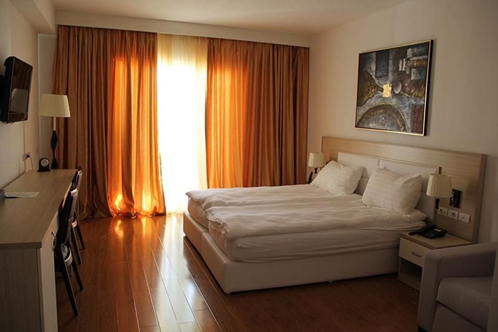 Une chambre d’hôtel avec un lit, un bureau et une chaise.