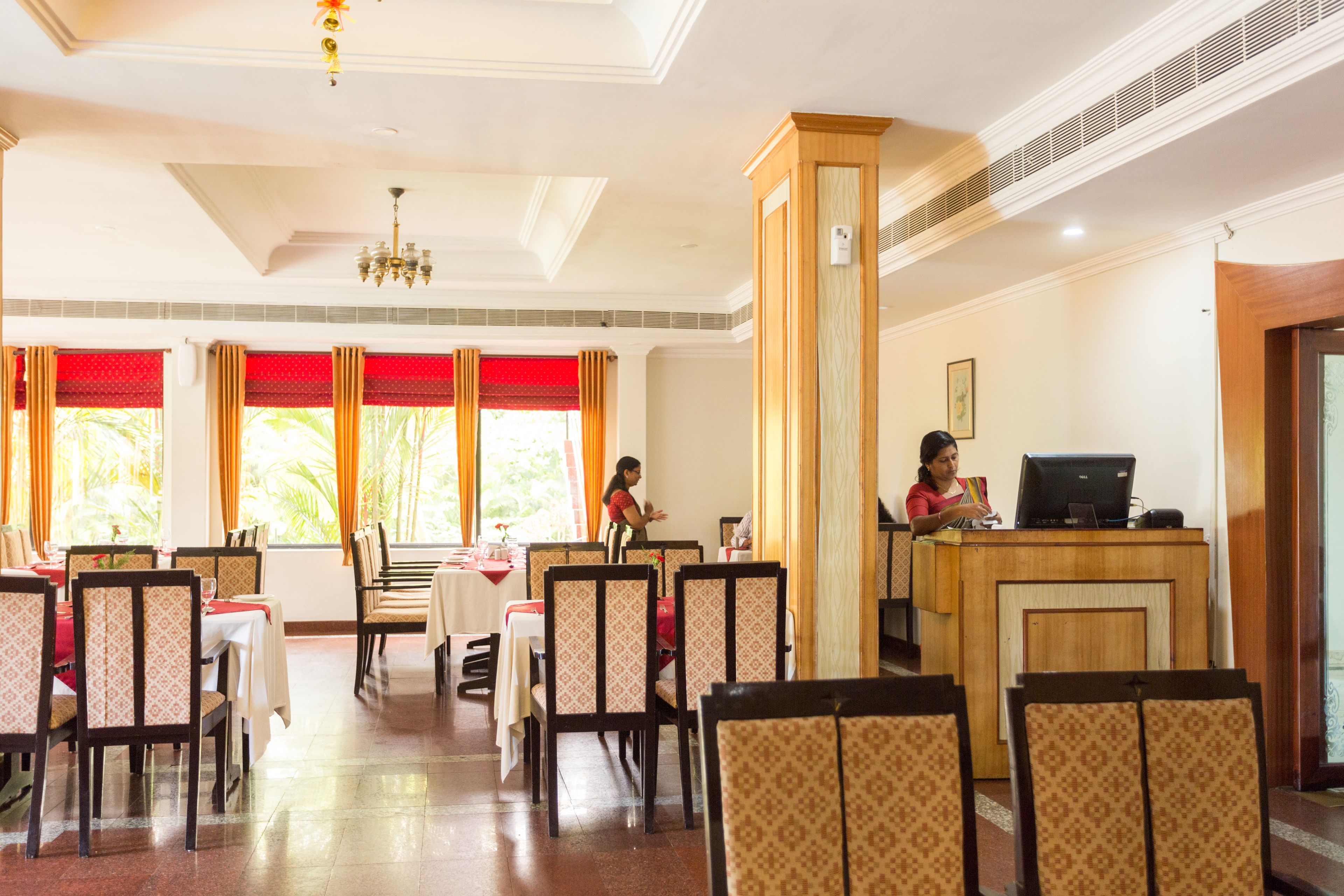 Un ristorante con tavoli e sedie, una reception e vista sull'esterno.