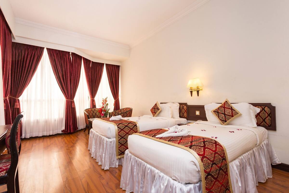 Una habitación de hotel con dos camas, un escritorio y una silla.