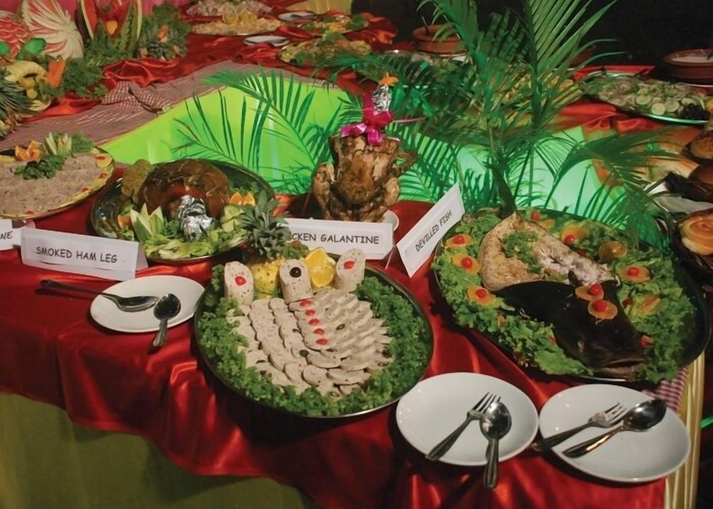 A buffet table with various dishes labeled, including smoked ham leg, chicken galantine, and devilled fish.