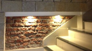 A staircase with a stone wall and a brick wall above it. - Lorenzo Suites Hotel (San Miguel de Tucuman)