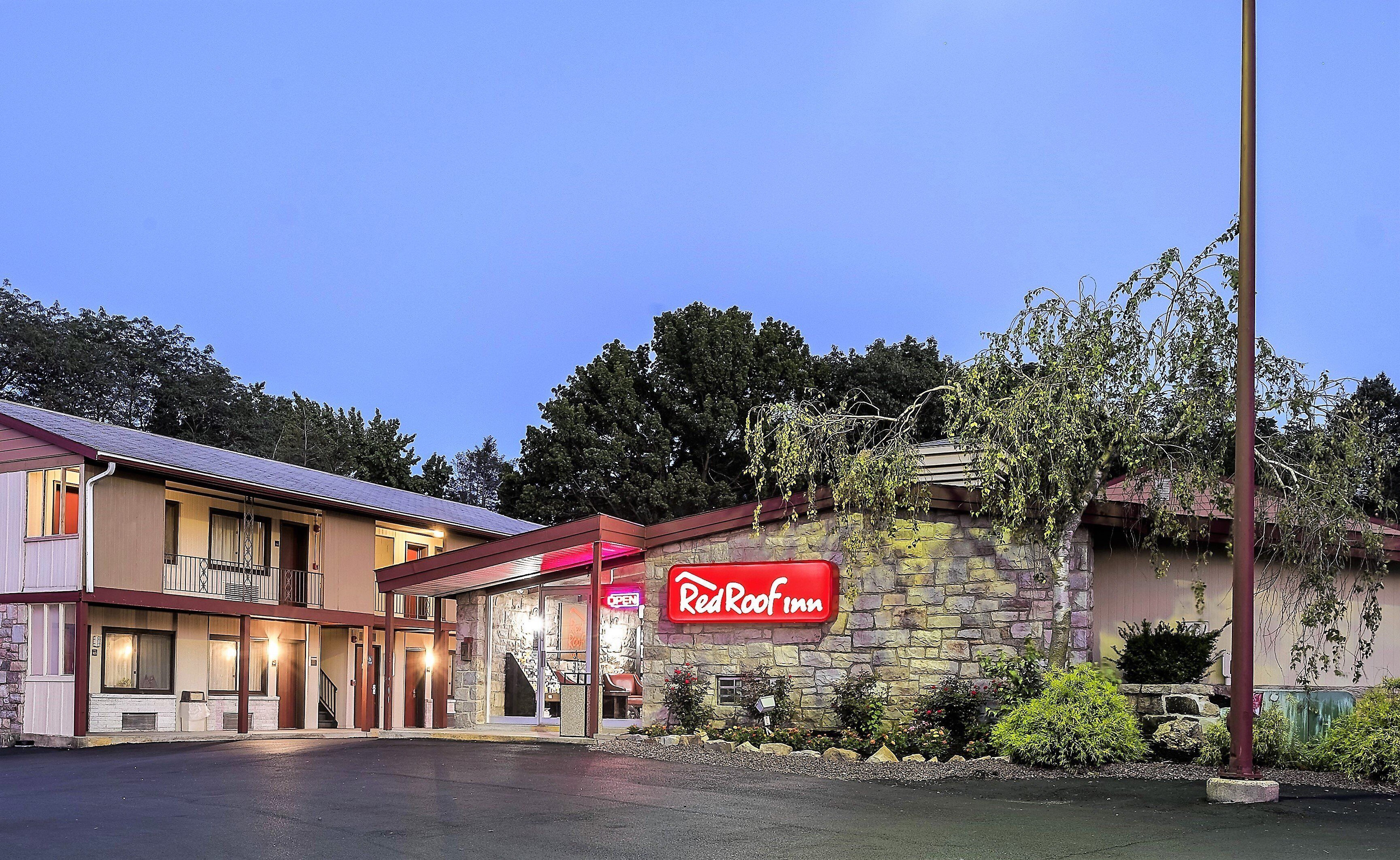 A Red Roof Inn with a stone facade, a visible entrance, and a parking lot.
