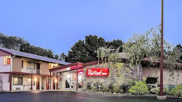 A Red Roof Inn with a stone facade, a visible entrance, and a parking lot.