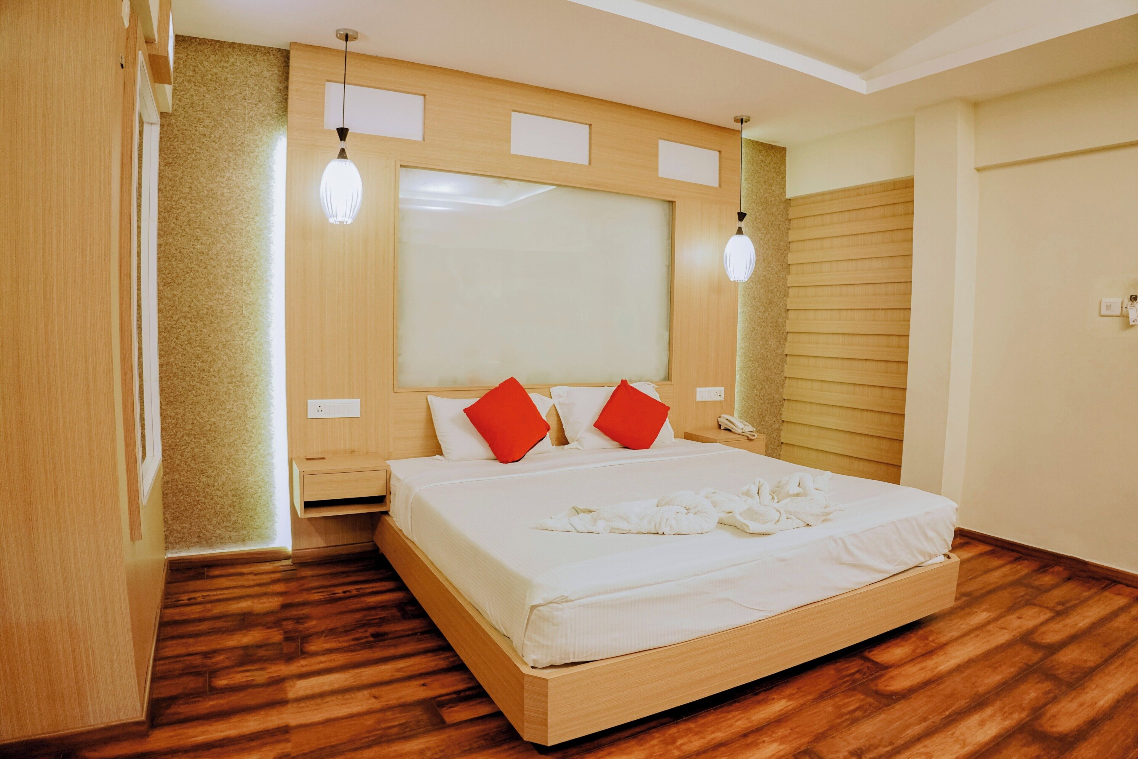 Ein Hotelzimmer mit einem hölzernen Bett, einem großen Fenster und einem Holzboden.