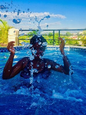 Een buitenzwembad, parasols bij het zwembad en ligstoelen