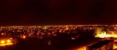 Un paisaje urbano nocturno con una luna grande en el cielo.
