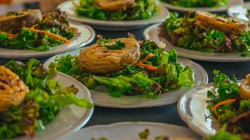 A table with multiple plates of food, each containing a piece of meat and a salad.