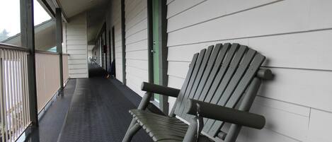 A covered outdoor area with a bench and a railing.