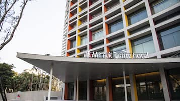 A modern hotel with a multi-story structure, featuring balconies and large windows.