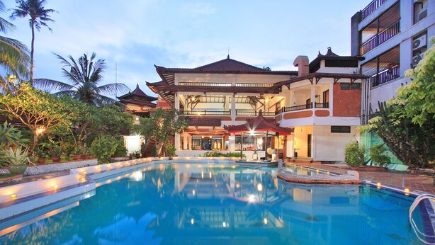 Un hôtel doté d’une piscine, d’une architecture traditionnelle et d’une végétation luxuriante.
