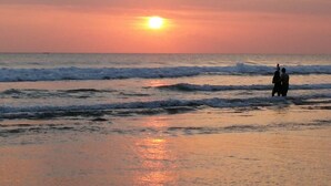 Un coucher de soleil sur l’océan, avec des vagues.