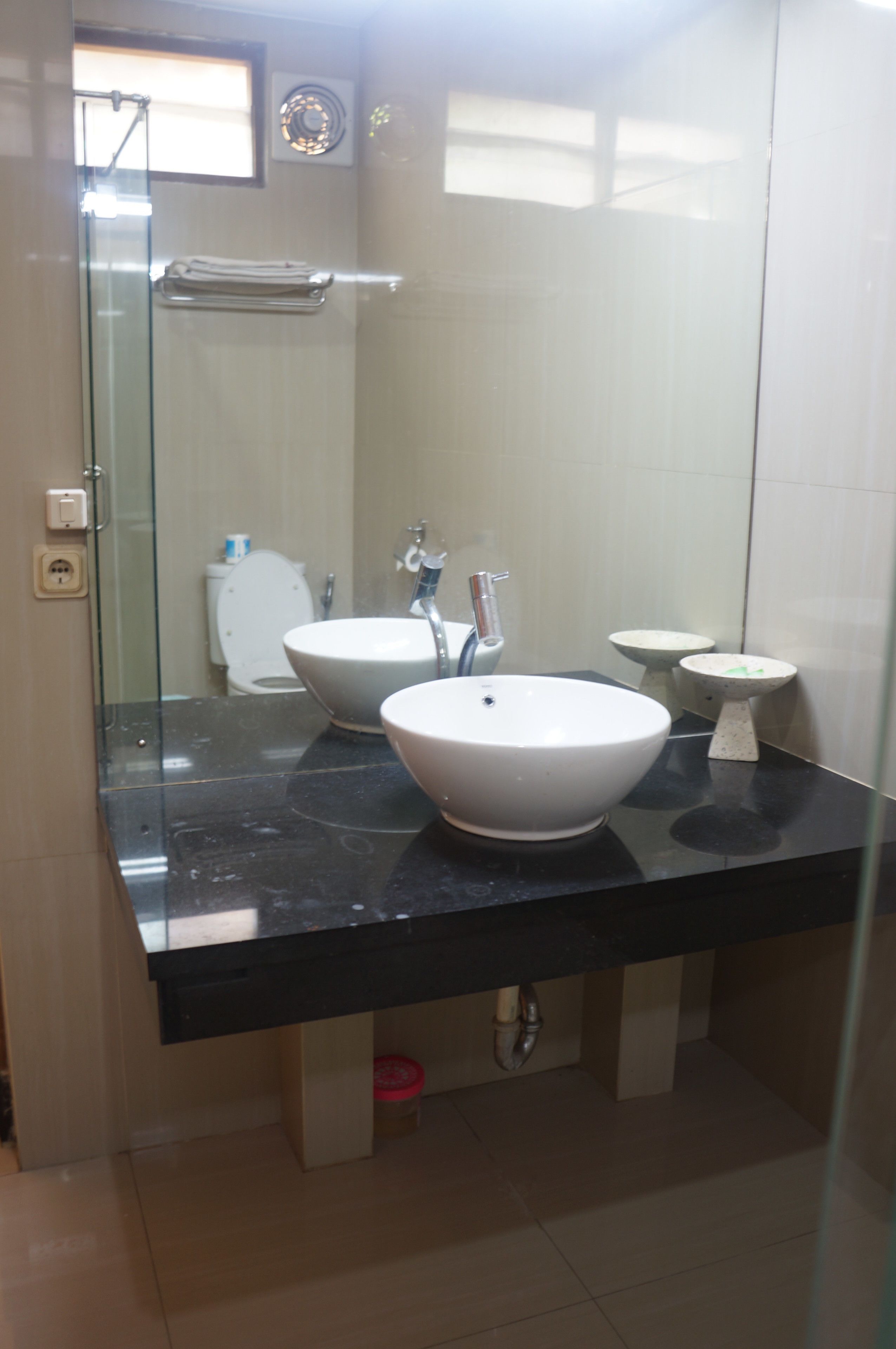A bathroom with two sinks, a glass shower enclosure, and a toilet.