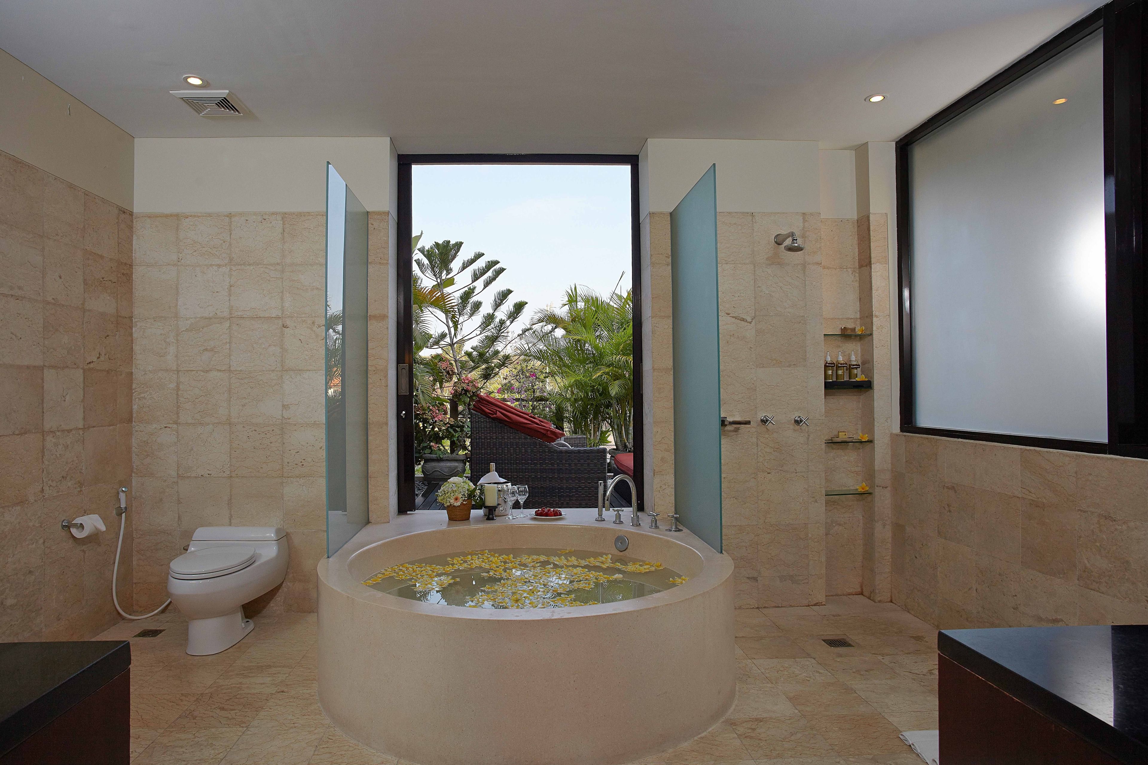 Ein modernes Badezimmer mit einer großen Badewanne, einer Toilette und einer Duschkabine.