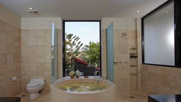 Ein modernes Badezimmer mit einer großen Badewanne, einer Toilette und einer Duschkabine.