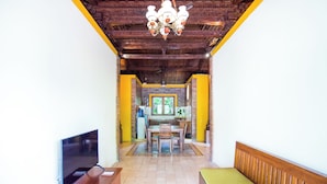 A living room with a TV, wooden furniture, a dining table, and a kitchen in the background. - Ubud Heaven Penestanan (Ubud)