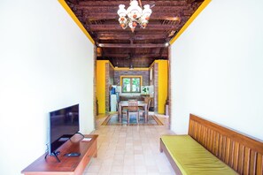 A living room with a TV, wooden furniture, a dining table, and a kitchen in the background. - Ubud Heaven Penestanan (Ubud)