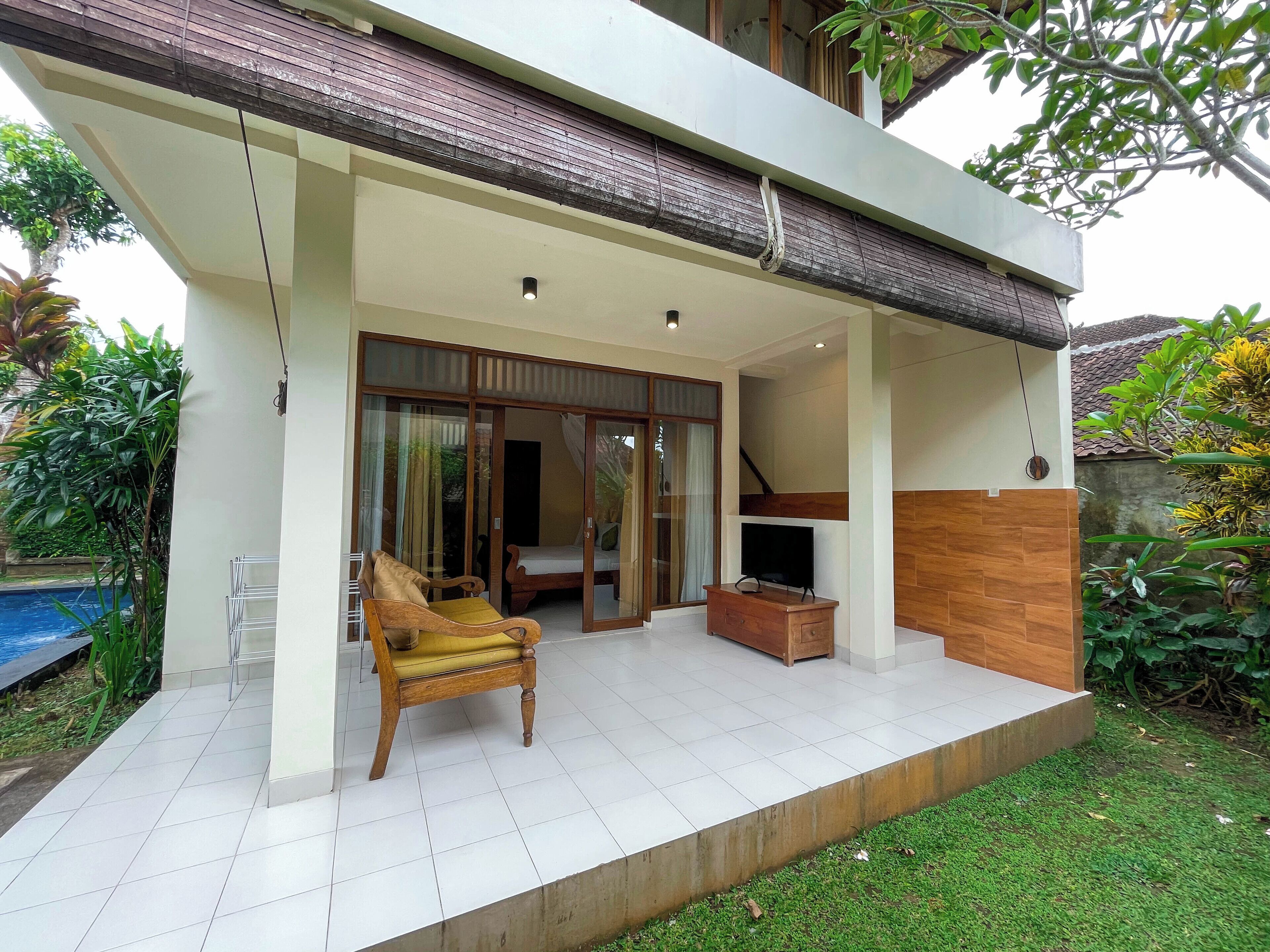 A modern house with a balcony, a TV, and a sofa.