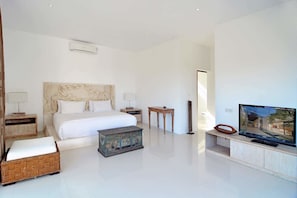A modern hotel room with a large bed, a television, and a small wooden table.