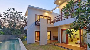 A modern two-story house with a swimming pool, large windows, and a balcony. - Scene Estate (Nusa Dua)