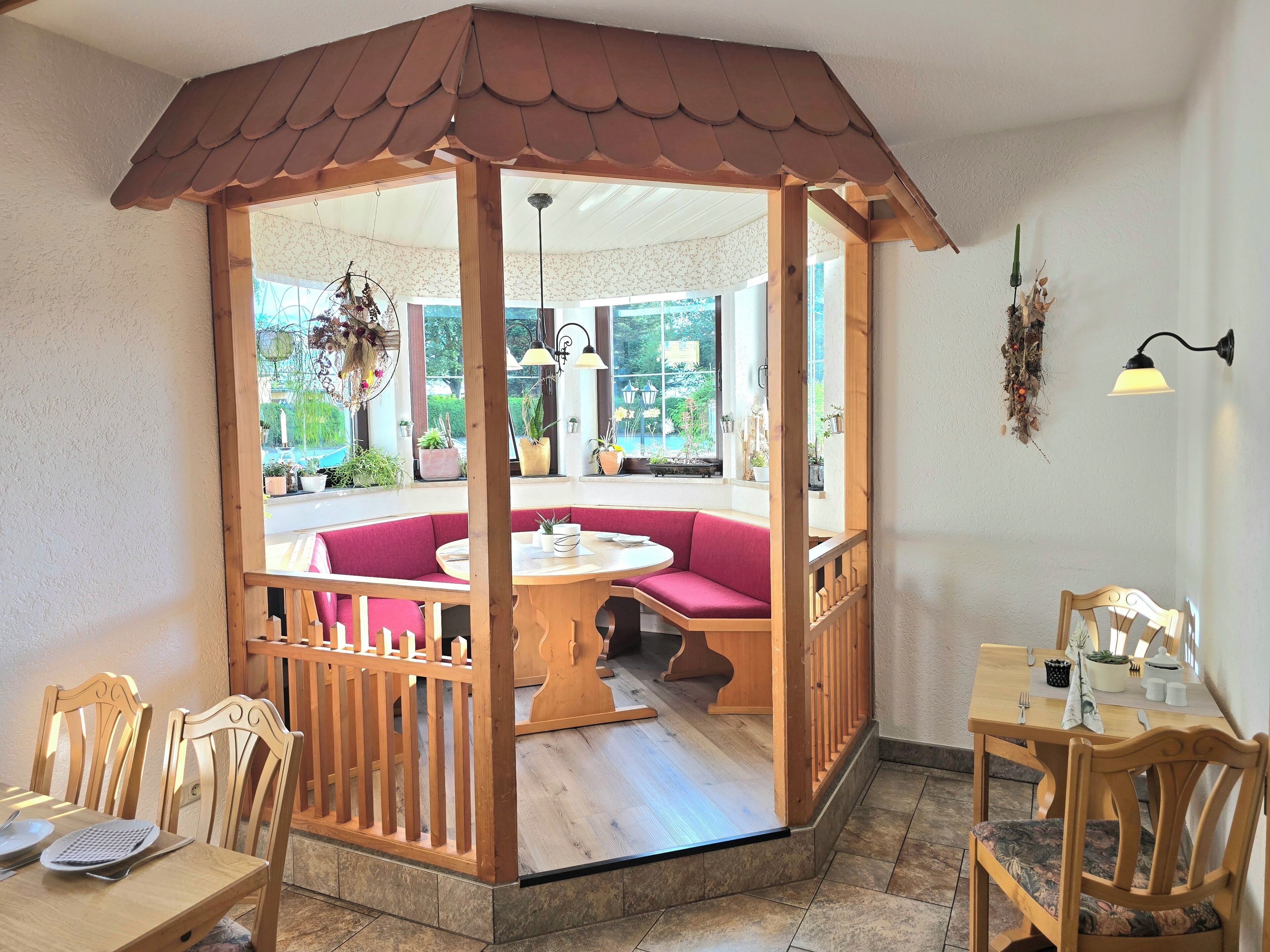 Une pièce chaleureuse avec une cloison en bois, une table ronde et un banc.