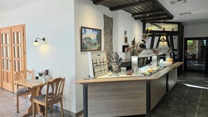 Un ristorante con un bancone in legno, sedie e un quadro appeso al muro.