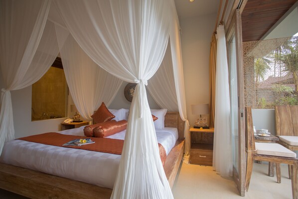 A bedroom with a bed, a nightstand, a chair, and a window with curtains. - Anulekha Resort and Villa (Ubud)