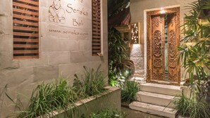 A villa named "Villa Seriska Bali" with a website address, a wooden door with intricate carvings, and a small window with wooden shutters. - Villa Seriska Seminyak Bali (Seminyak)