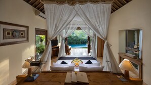 A bedroom with a canopy bed, a view of a pool, and a wooden ceiling. - The Sankara Resort & Spa (Ubud)