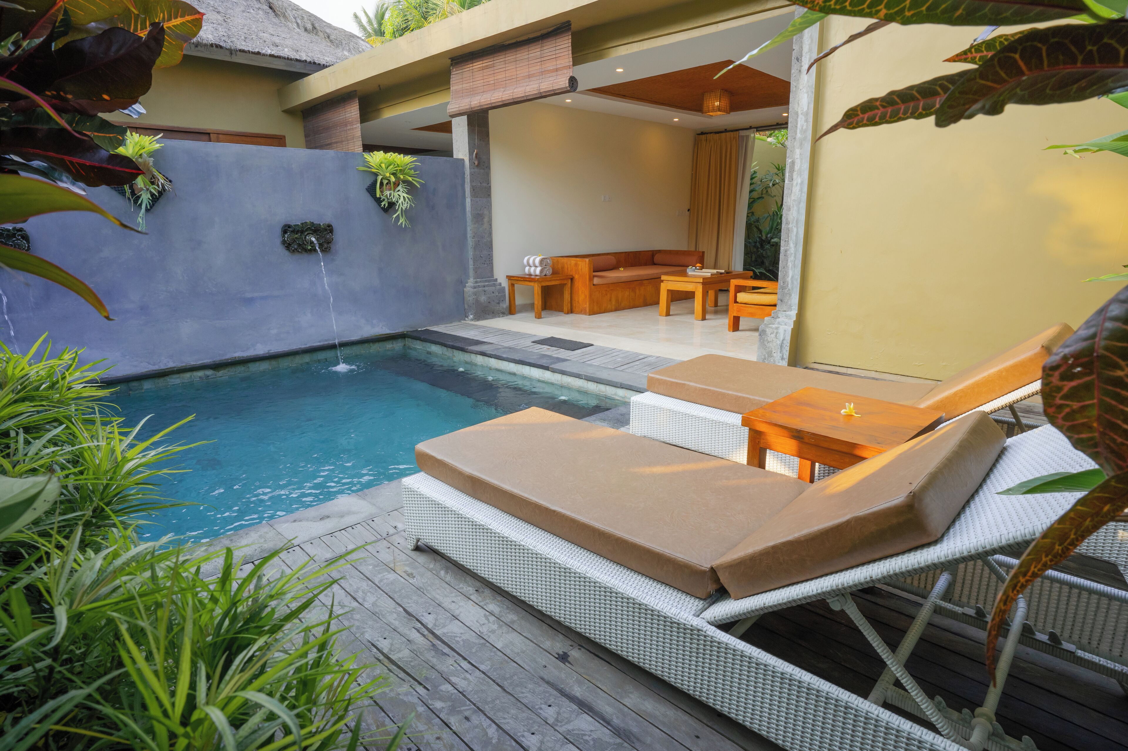 A pool area with lounge chairs and a seating area.