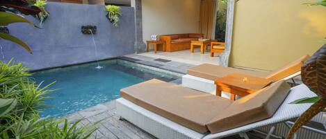 A pool area with lounge chairs and a seating area.