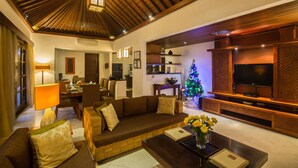 A living room with a wooden ceiling, a television, a sofa, and a Christmas tree. - Villa Seriska Satu Sanur Bali (Denpasar)