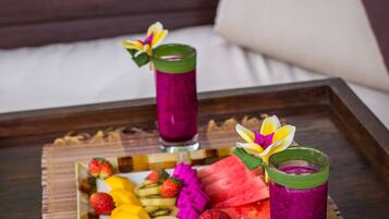 A tray with a book titled "Secrets of Bali" and two drinks on a wooden table.