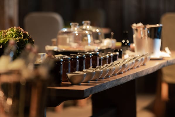 A bar area with a long counter displaying various bottles and bowls. - Zannier Le Chalet (Megeve)